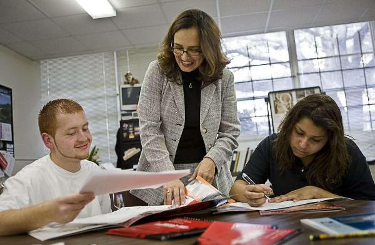 In this 2008 file photo, Sam Houston High seniors Edwin Villarreal, 18, and Ana Alas, 17, put together college applications and scholarship packets with the help of college access coordinator Ivonne Rodriguez.