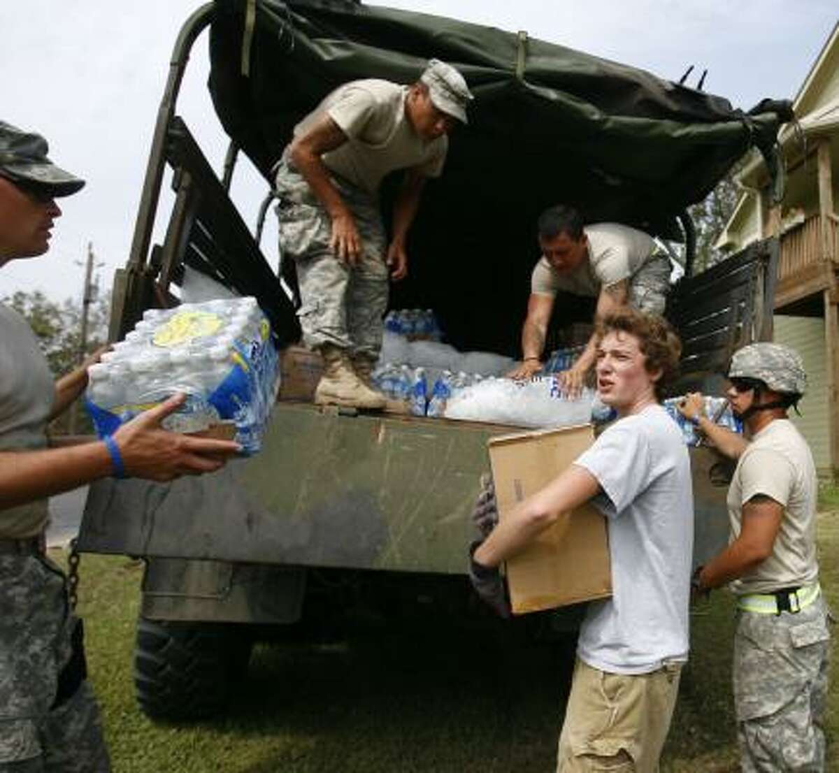 Ryan Wallace picks up food, water and ice from the Texas Army National Guard for his grandmother who lives in San Leon.