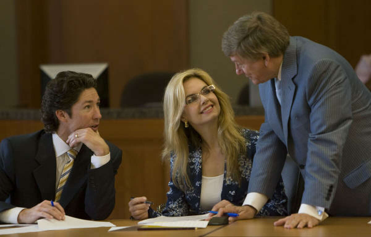 Victoria Osteen and her husband, Joel, sit in the courtroom as they talk with her attorney, Rusty Hardin, before jury selection in the trial of an airline flight attendant's lawsuit against Victoria.