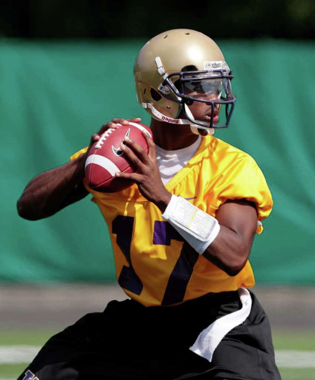 Washington quarterback Keith Price drops back to pass during the NCAA college football team's first practice of the season, Monday, Aug. 8, 2011, in Seattle.