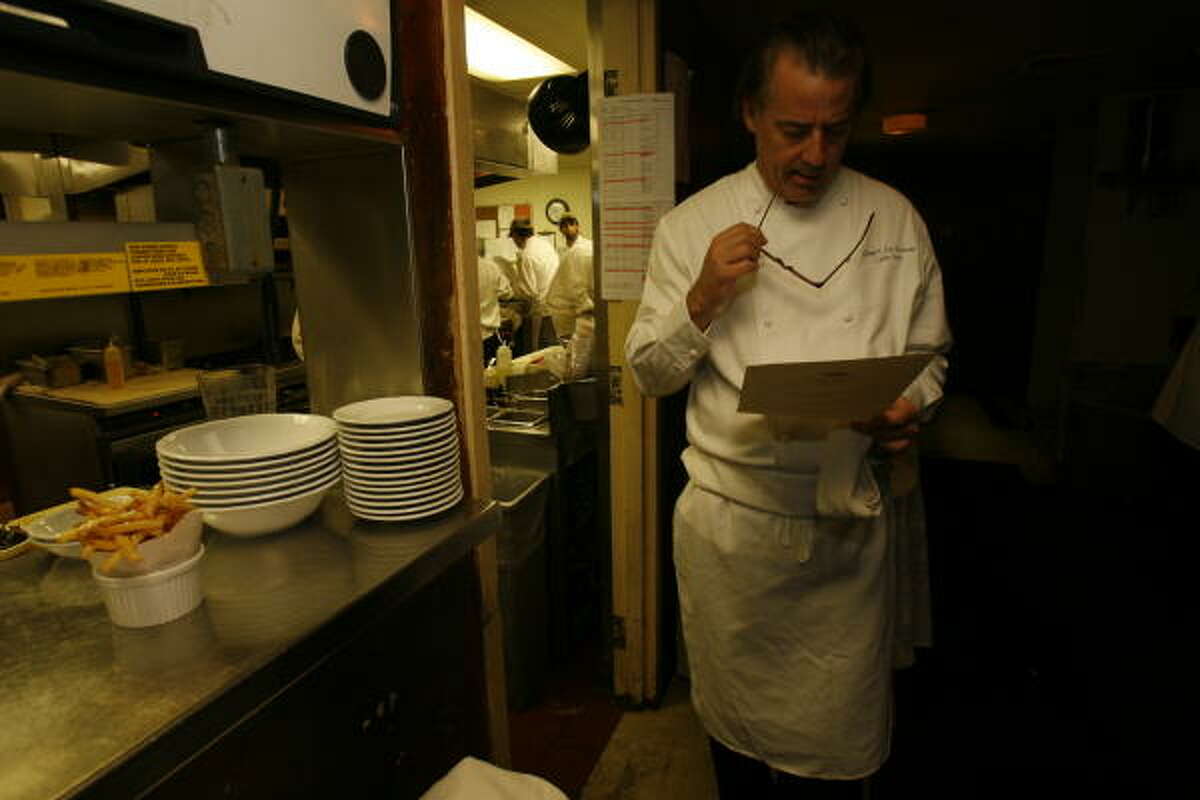 Chef Robert Del Grande looks over a list of dishes ordered by a party at Cafe Annie. Del Grande is the only chef in Houston to win the James Beard Award as Best Chef of the Southwest.