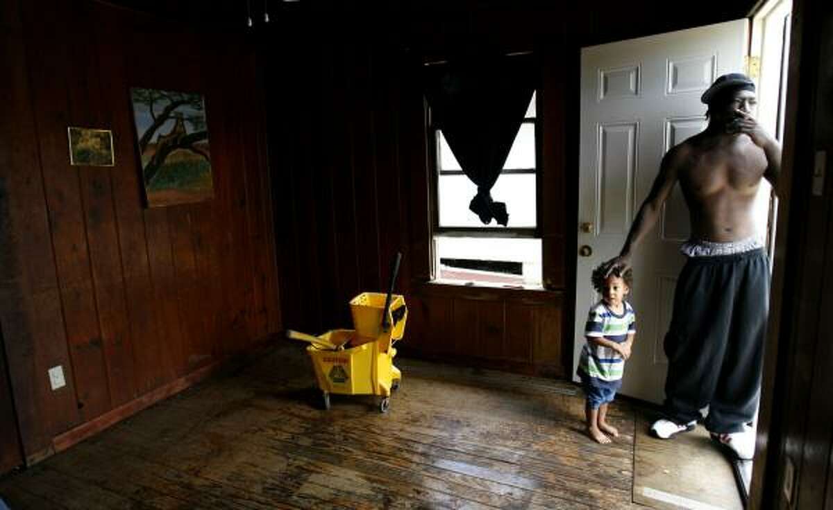 Michael Jackson with his son, Howard, 2, stands in Howard's room, damaged by Hurricane Ike, in the Fifth Ward on Tuesday.