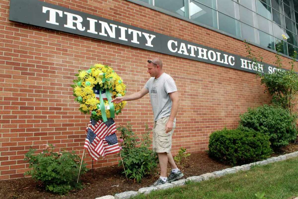 Pat Sasser a classmate and friend of Brian Bill, the Navy Seal killed in Afghanistan, place a memorial wreath at Trinity Catholic High School in Stamford, Conn. on Tuesday August 9, 2011.