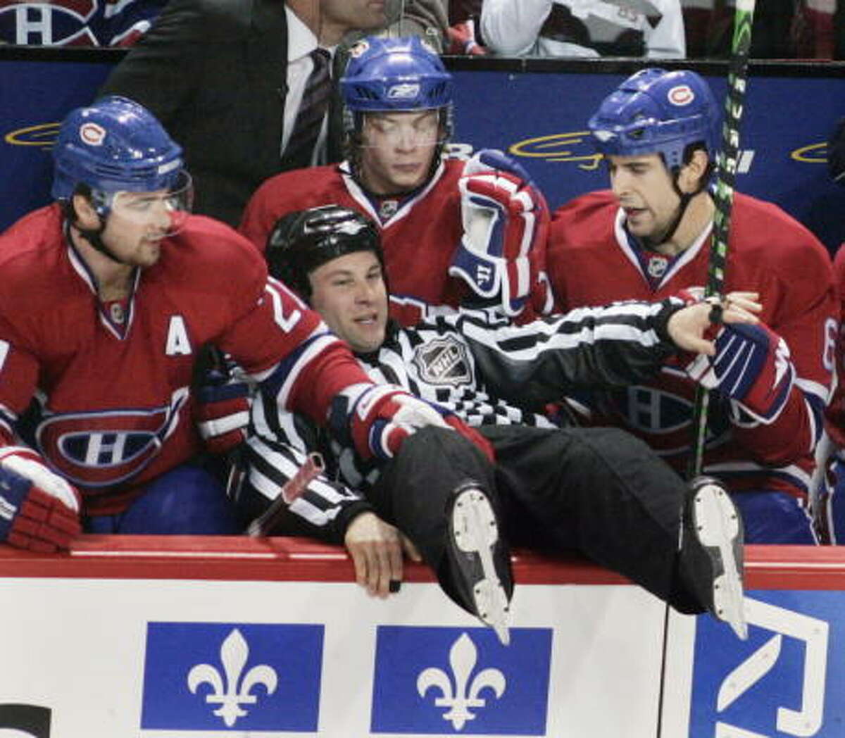 Linesman Mark Shewchyk falls into the Montreal Canadiens' bench.