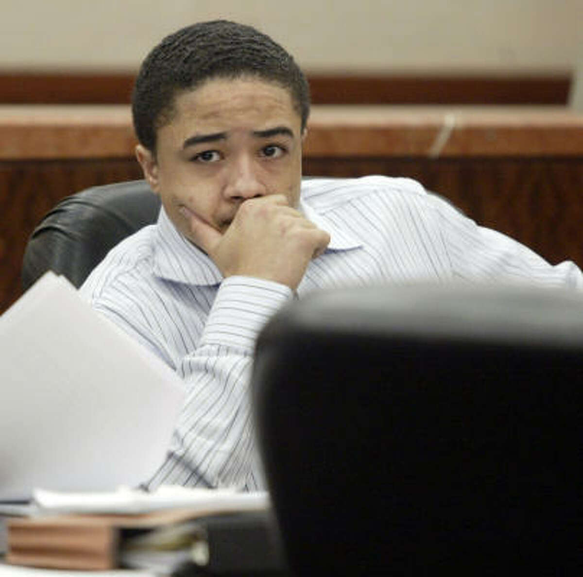 Dexter Johnson, 19, sits at a table during his trial June 13 in the 208th District Court of the Harris County Criminal Courthouse in Houston.