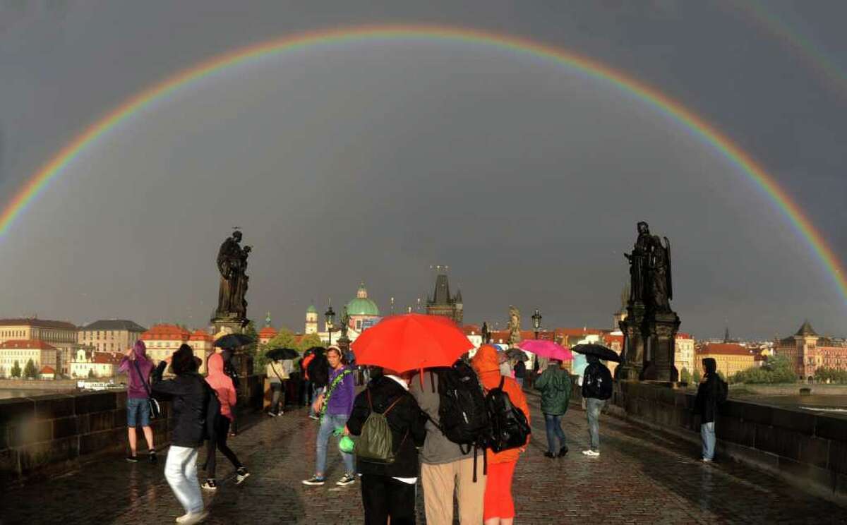 Rainbows are caused by water droplets spreading light into its spectrum of colors. Notice that the sun is alwasy behind you when you face a rainbow, with rain in the direction of the rainbow. Here are some cool rainbows in interesting places around the world, starting with one on August 9, 2011 above the medieval Charles Bridge in Prague, Czech Republic.