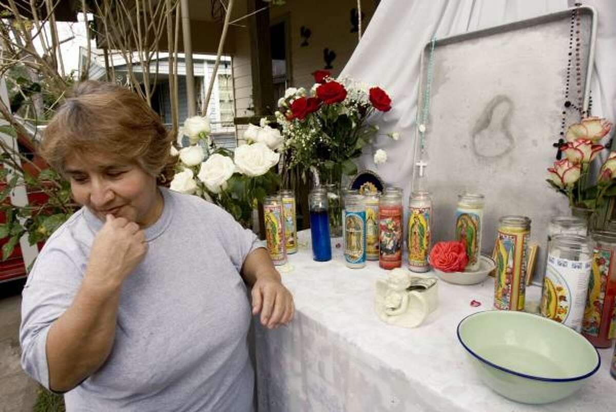 Guadalupe Rodriguez, who discovered the Virgin Mary image, stands next to a makeshift display at a Denver Harbor residence.