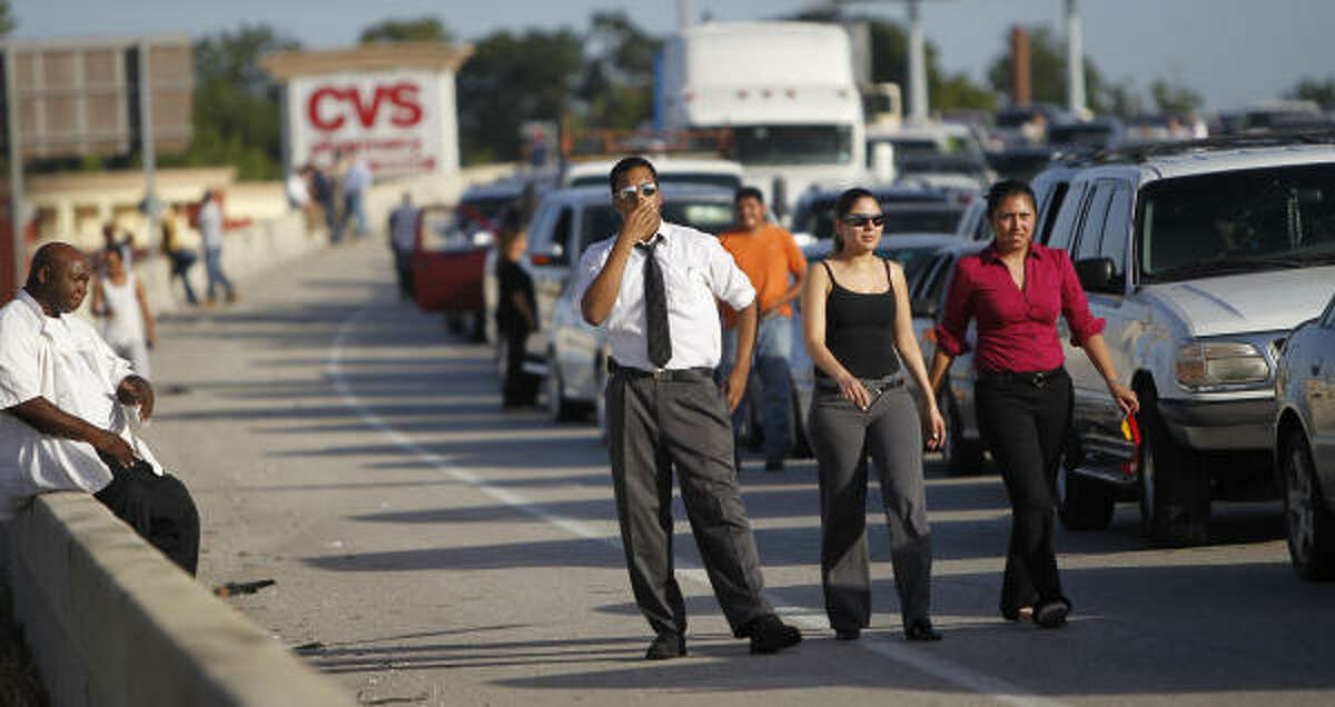 Commuters get out of their cars as they watch officials try to clean up the wreck site. Northbound traffic was backed up for several miles, and officials considered closing southbound lanes as well. Karen Warren/Houston Chronicle
