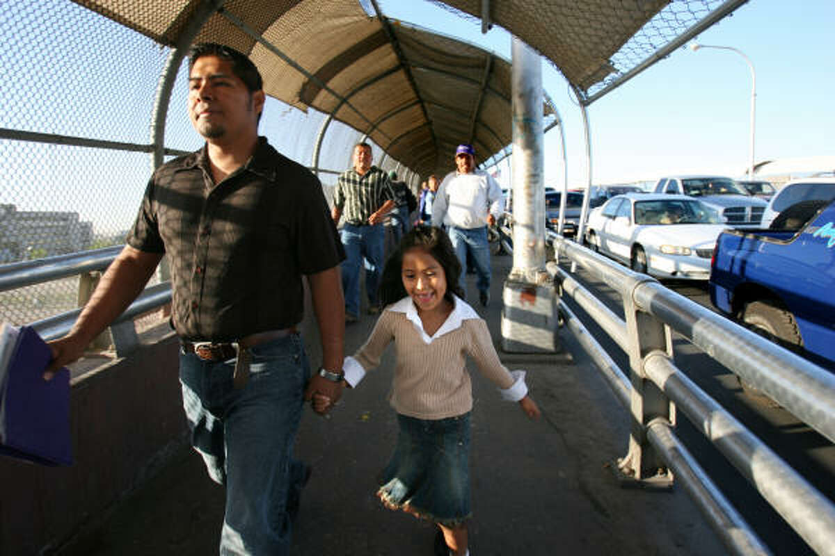 Aaron Ortiz walks his daughter Rachel, 6, across the border from their home in Juarez to her El Paso school each morning.