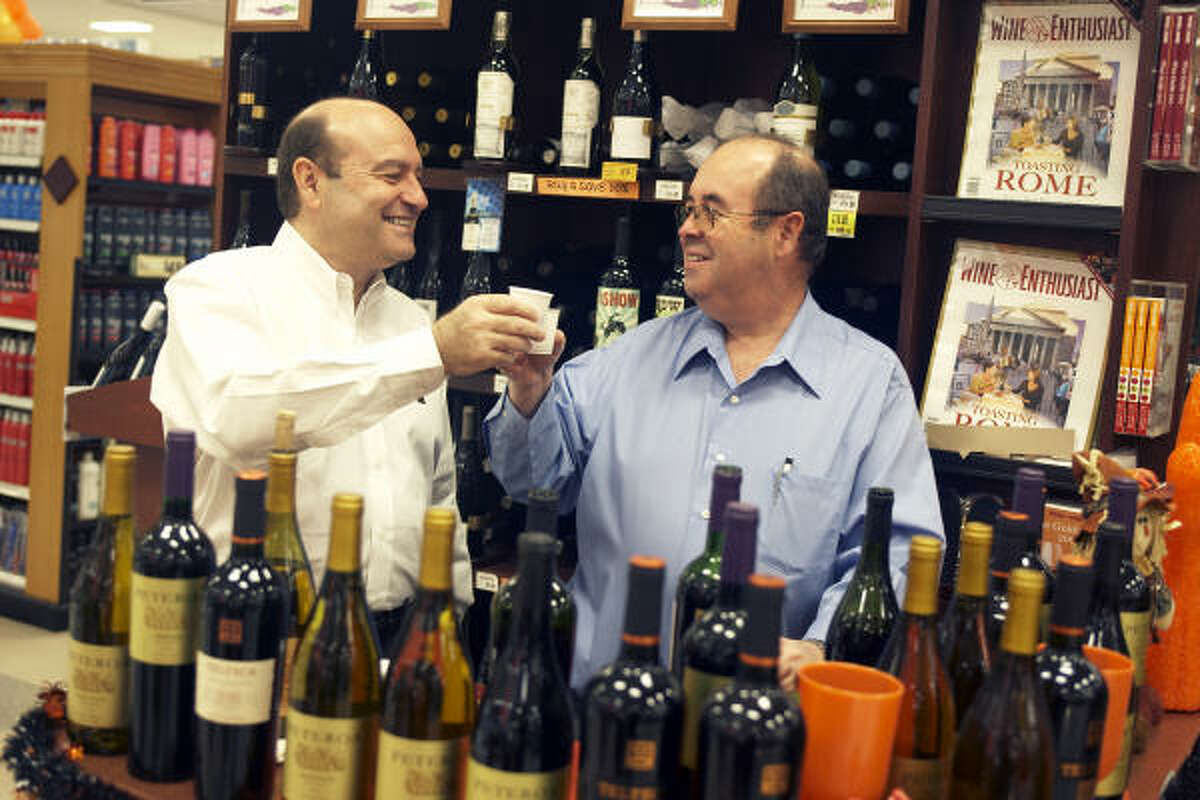 Micky, left, and Roberto Fleischer, founders of Fleischer International Trading, promote their imported Chilean wine at the Kroger on Westpark and Buffalo Speedway. The weakened dollar has hurt Chilean exporters, who must take the losses in order to compete in the U.S. market.