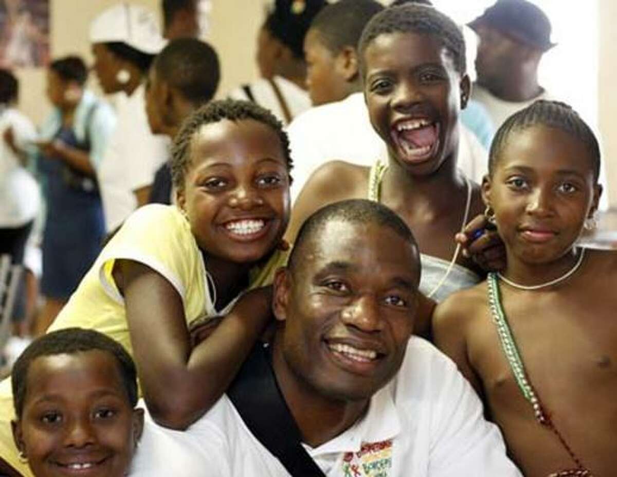 Dikembe Mutombo visits with students at the American International School in Johannesburg, South Africa.