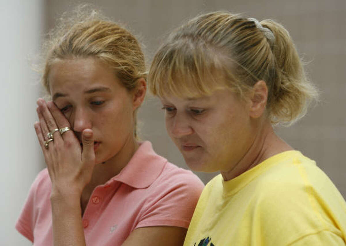 Leanna Brandon, left, wipes her eyes while recounting the loss of her pets and belongings with her cousin Janette Bates on Friday.