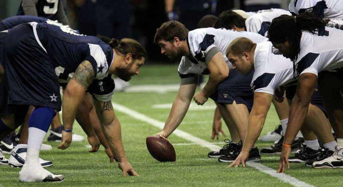 Cowboys defense (blue, left) and offense (white, right) head off during training camp at the Alamodome on Tuesday, Aug. 9, 2011.
