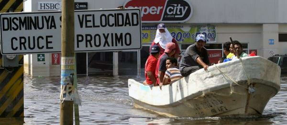 Residents are driven in fishing boats along flooded streets in Villahermosa on Tuesday. Oil fields in the Mexican region are largely unscathed, but many oil workers have lost their homes.