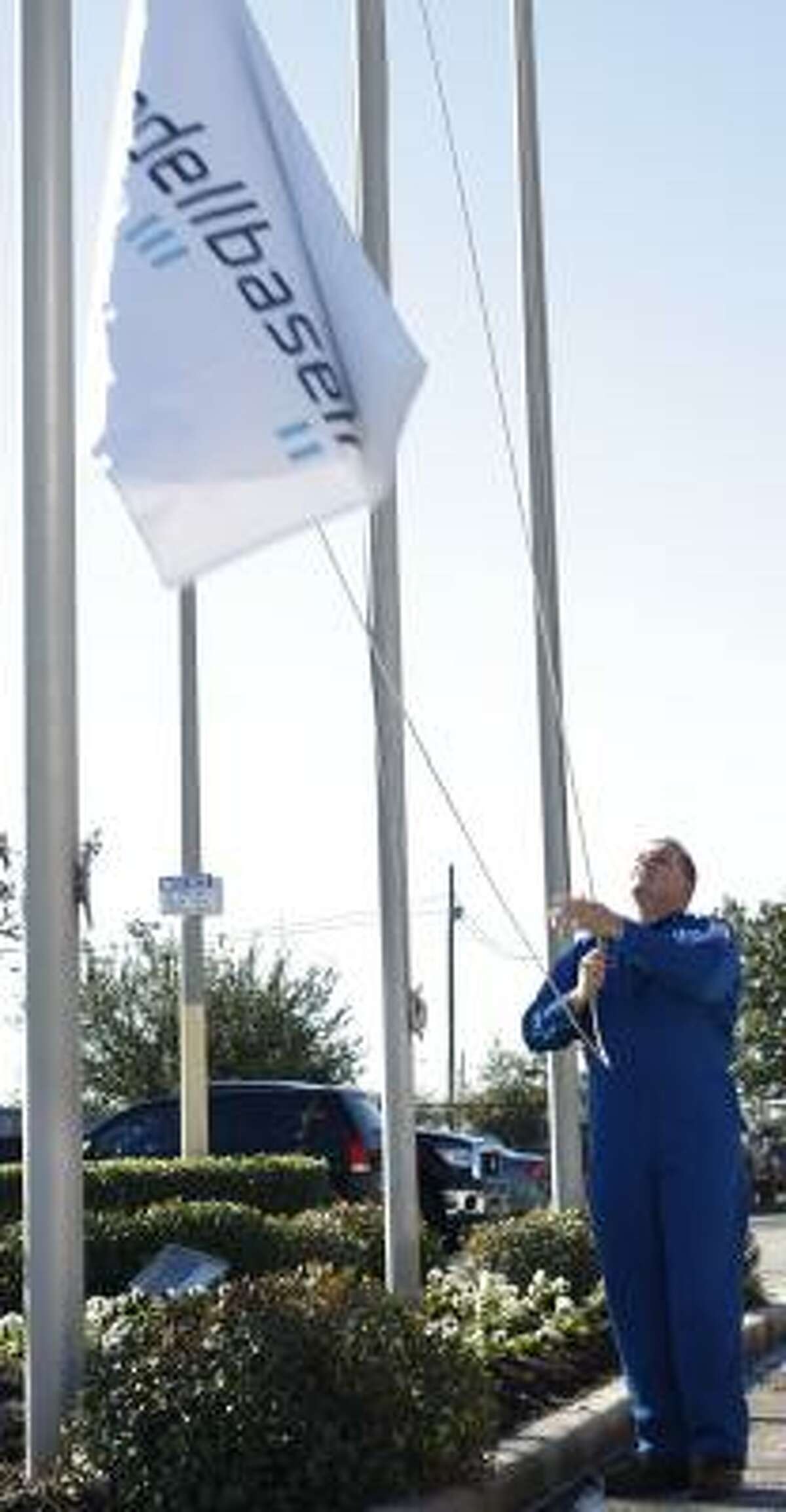 Operation superintendent Ryan Miller raises the new corporate flag at the LyondellBassell Industries refining plant in Houston on Thursday.