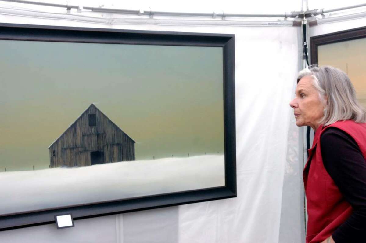 Kaysie Goodenough eyes painter Gary Stretar's "Winter Barn" as she browses the Bruce Museum's 28th annual Outdoor Arts Festival Saturday morning, Oct. 10, 2009. The festival is a juried event featuring more than 90 artists selected from across the country and features paintings, photography, drawings, prints, sculptures and mixed media pieces. It continues through Sunday running from 10 a.m. to 5 p.m. on the museum’s grounds,