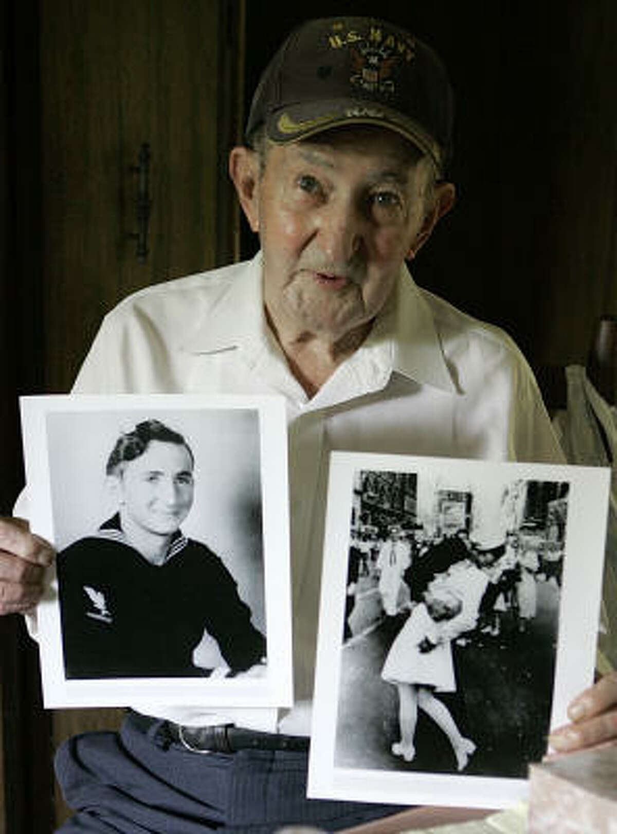 Glenn McDuffie holds a portrait of himself as a young man, left, and a copy of Alfred Eisenstaedt's iconic Life magazine shot of a sailor embracing a nurse. McDuffie says he is the sailor in the photo.