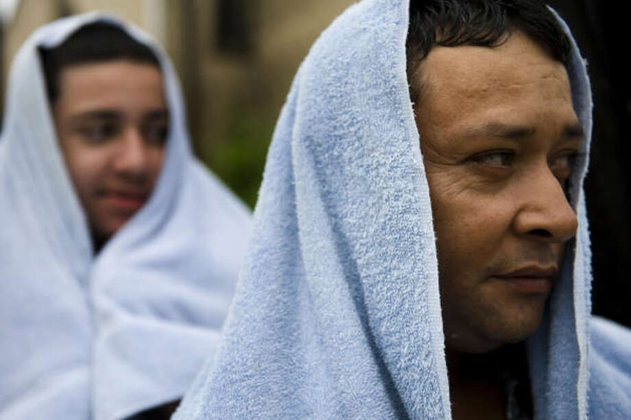 Shelter | Adolfo Navia and his son Miguel emerge from sheltering at Christ the King Catholic Church to survey damage on North Main Street near downtown. | Sept. 13 | Houston Photo: Smiley N. Pool, Houston Chronicle