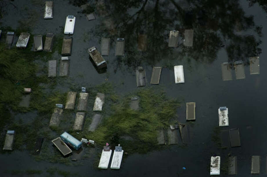 Unearthed | Murky water inundates a cemetery. | Sept. 14 | Orange Photo: Smiley N. Pool, Houston Chronicle