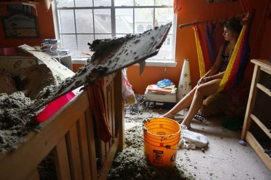 No place safe | Alison Naquin, 14, takes a measure of all the damage to her bedroom. Naquin was in the game room with the rest of her family when the roof caved in over her bed. | Sept. 13 | Pearland Photo: Mayra Beltran, Houston Chronicle