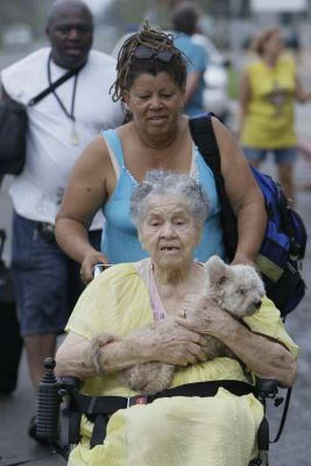 Going home | | Aletia Skies pushes her mother, Emma Yarborough, and her dog, Pablo, in a wheelchair as her husÂband, Robert Sikes, carries their belongings. The family said the bad conditions at the shelter prompted them to leave. | Sept. 13 | Galveston Photo: Melissa Phillip, Houston Chronicle
