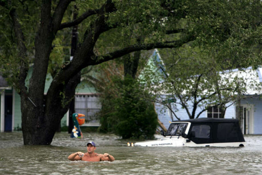 In too deep| Chris Symank leaves his flooded Jeep after checking on a friend's house. He said he forgot about the road's dip in that spot until it was too late. | Sept. 12 | Kemah Photo: Eric Kayne, Houston Chronicle