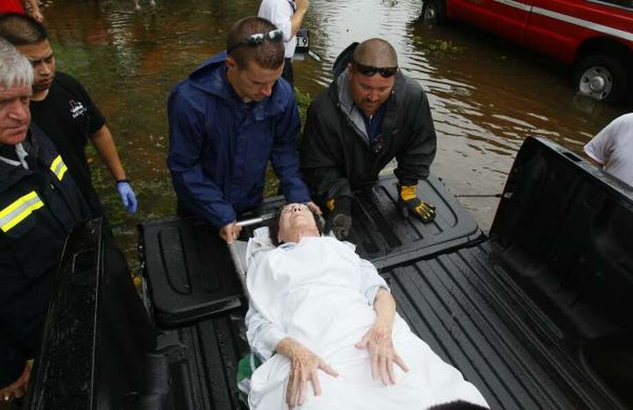 Improvisation | A pickup is turned into a makeshift ambulance as 76-year-old Peggy Eisworth is placed in the bed of the truck to be carried to a hospital. Eisworth tripped in the dark and broke her hip. | Sept. 13 | Pearland Photo: Mayra Beltran, Houston Chronicle
