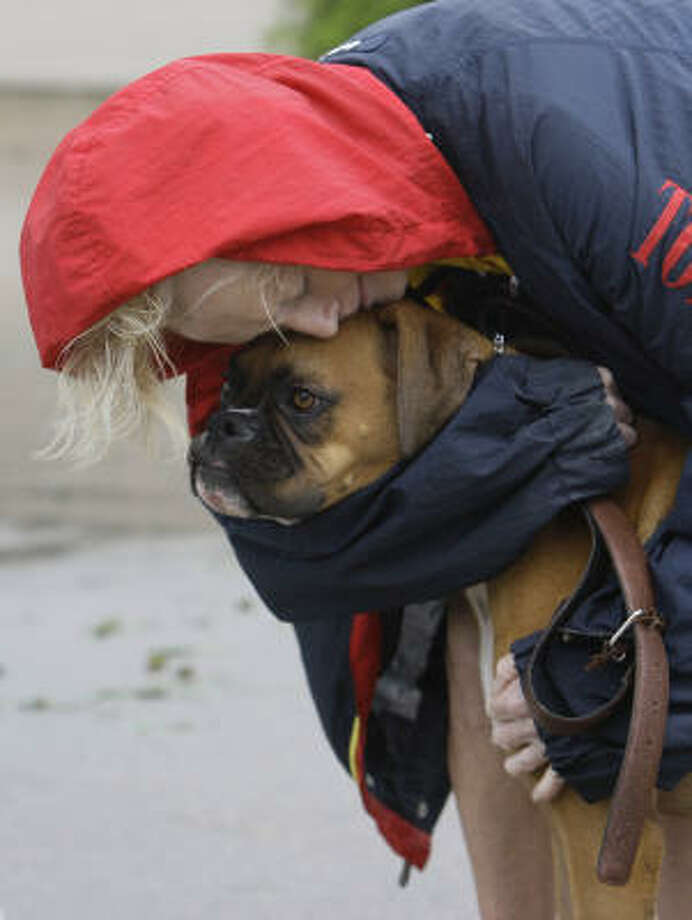 From the fire| Frederika Kotin hugs her dog, Belle. Kotin's townhouse was one of six in a row that burned on Beaudelaire Circle. | Sept. 13 | Galveston Photo: Melissa Phillip, Houston Chronicle