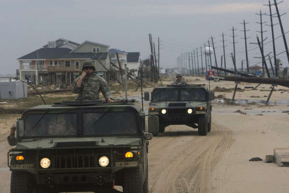 Rescue mission | Members of the Army National Guard's C-Troop make their way past the destruction to rescue two stranded women in the Pointe West neighborhood. | Sept. 14 | Galveston Photo: Johnny Hanson, Houston Chronicle