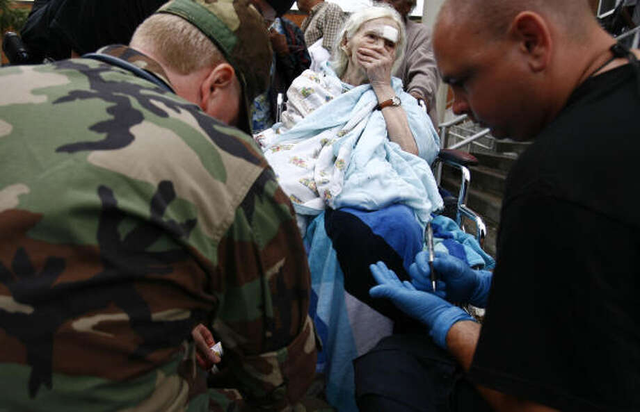 Bundled up | Alina Van Epps is evaluated by emergency personnel as she waits to be evacuated. | Sept. 14 | Galveston Photo: Sharon Steinmann, Houston Chronicle