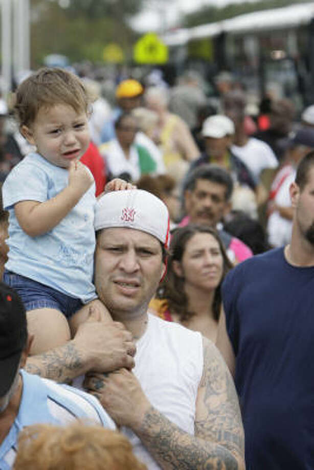 Among the masses | Gilbert Cisneros holds his two-year-old daughter, Gillissa, as they wait in line to be evacuated. | Sept. 14 | Galveston Photo: Melissa Phillip, Chronicle