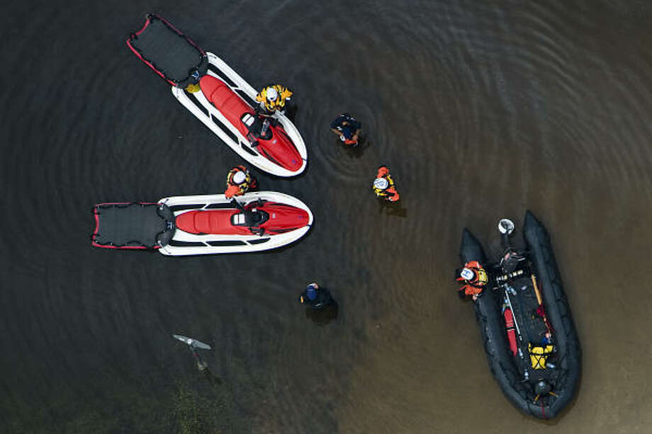 Plan of action | Rescue boats convene near a stop sign on a flooded road. | Sept. 14 | Bridge City Photo: Smiley N. Pool, Houston Chronicle