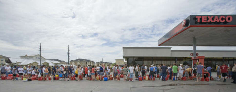 Long wait | Customers lined up for as long as three hours to buy gas at Texaco, one of the few open stations. The station used a generator to keep powered up. | Sept. 14 | Spring Photo: Steve Campbell, Houston Chronicle