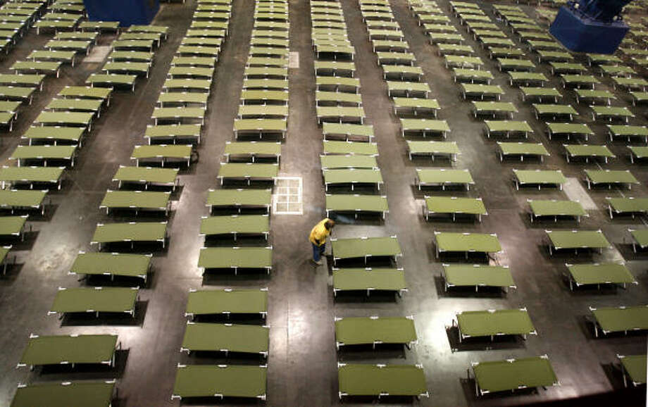 Sea of cots | A volunteer arranges cots at the George R. Brown Convention Center, where the Red Cross and other organizations set up a staging center for evacuees. | Sept. 15 | Houston Photo: Karen Warren, Houston Chronicle