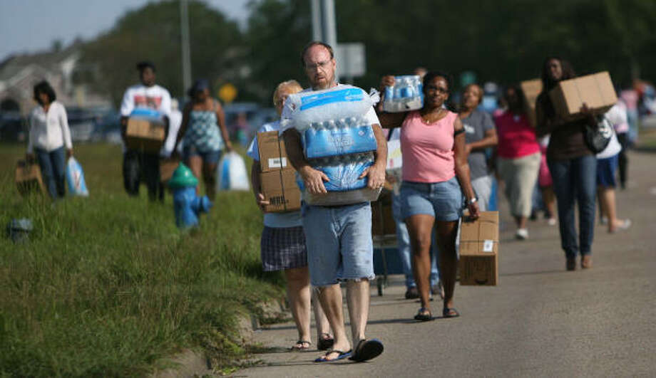 Loaded down| Residents return to their vehicles after receiving their allotment of FEMA supplies. | Sept. 15 | Houston Photo: Mayra Beltran, Houston Chronicle
