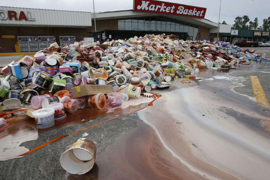 Inedible | Thawed foodstuffs pulled from the shelves of the Market Basket grocery are piled high in front of the store. | Sept. 15 | Winnie Photo: James Nielsen, Houston Chronicle