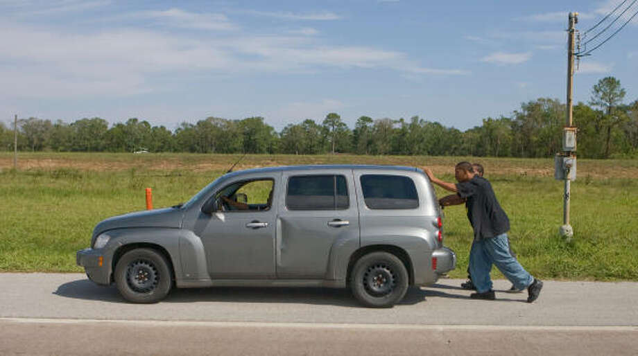 A little push | Jevin Gardner steers his car as his friends, Bobby Lewis and Terry Ross, push it to a gas station after it ran out of fuel on Beltway 8. | Sept. 15 | Spring Photo: Steve Campbell, Houston Chronicle