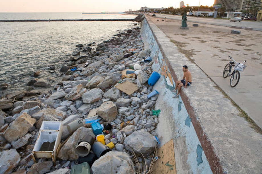 Taking it all in| Lucas Betances sits on the Seawall near the memorial to the Great Storm of 1900. "There's no beach," Betances said, stunned. "The ocean ate the sand." | Sept. 29 | Galveston Photo: Steve Campbell, Houston Chronicle