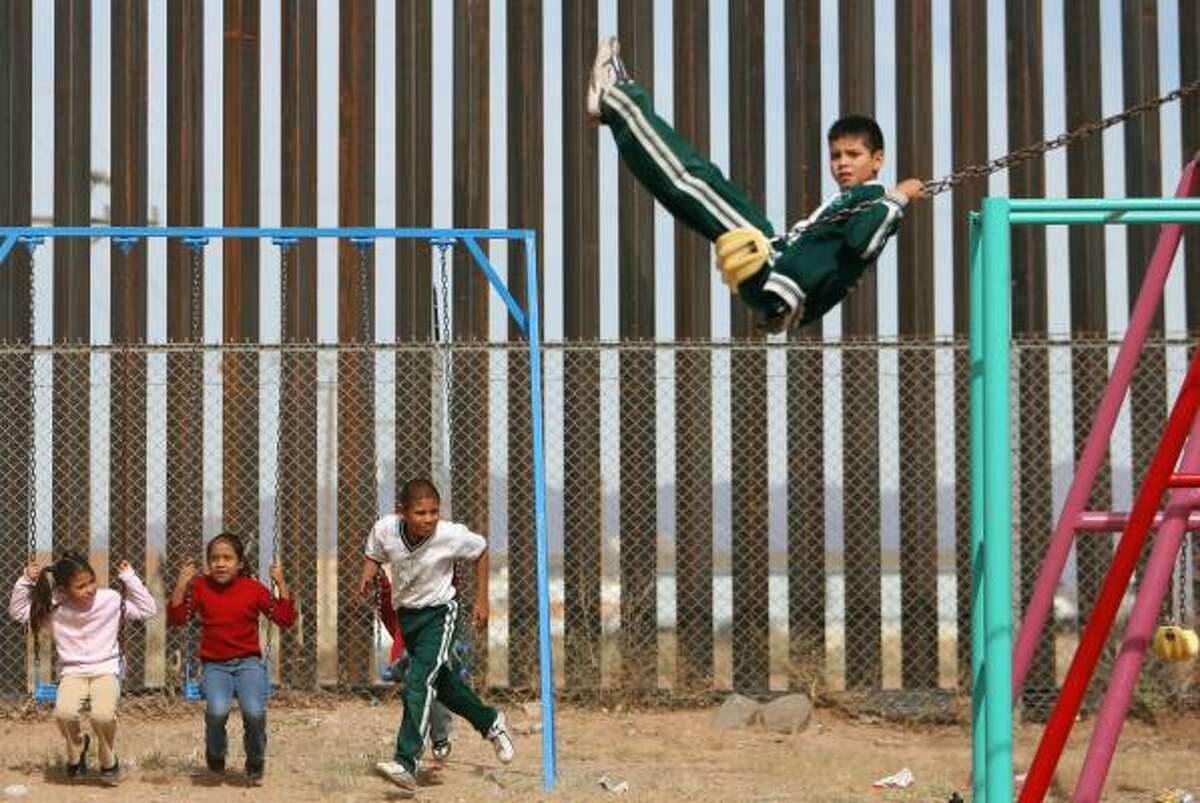 Fifteen-foot-high girders of a newly completed segment of the U.S. border fence abut a school playground in Palomas, Mexico, across the line from Columbus, N.M.