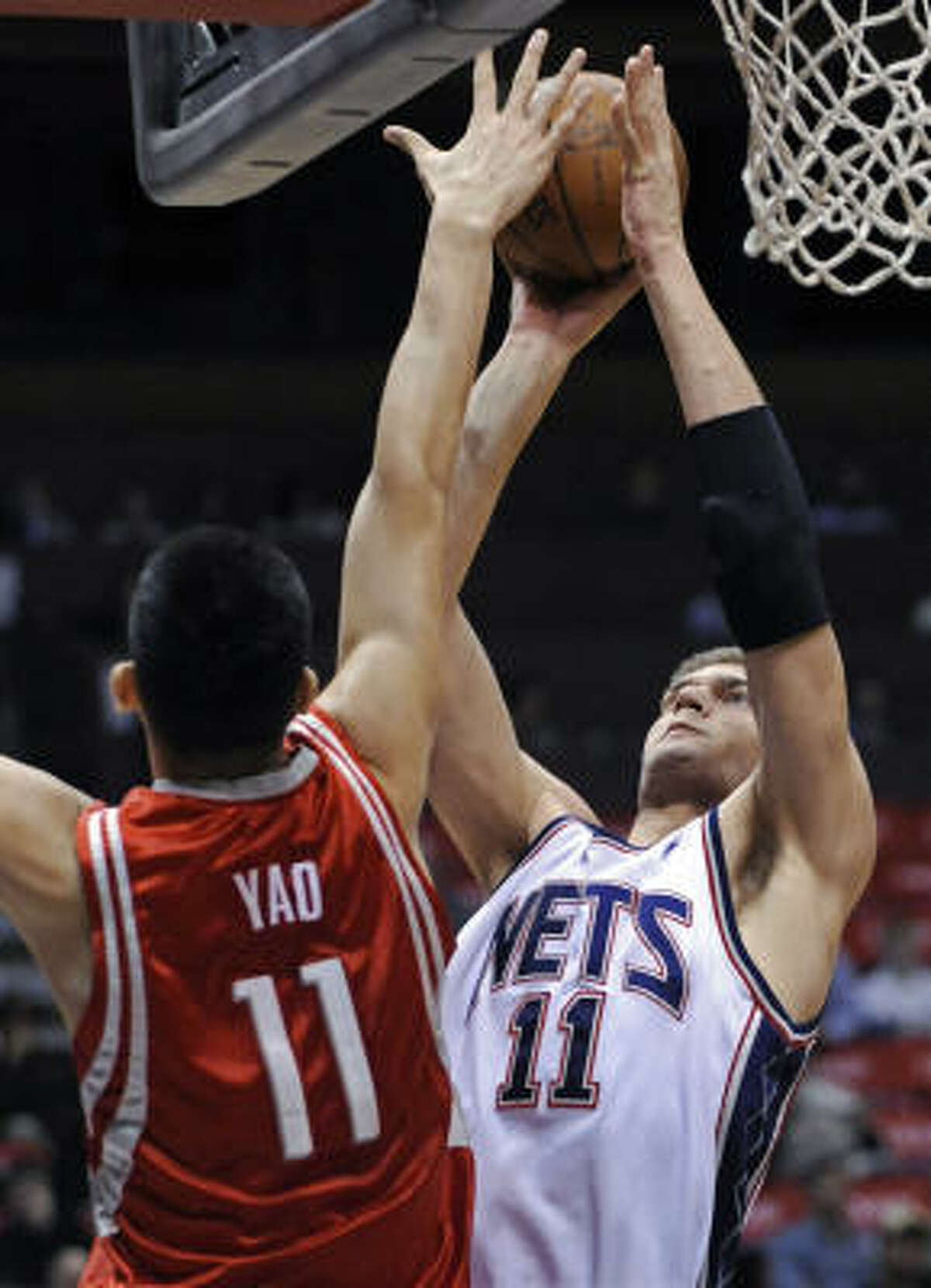 New Jersey Nets' Yi Jianlian, of China, left, blocks a shot by