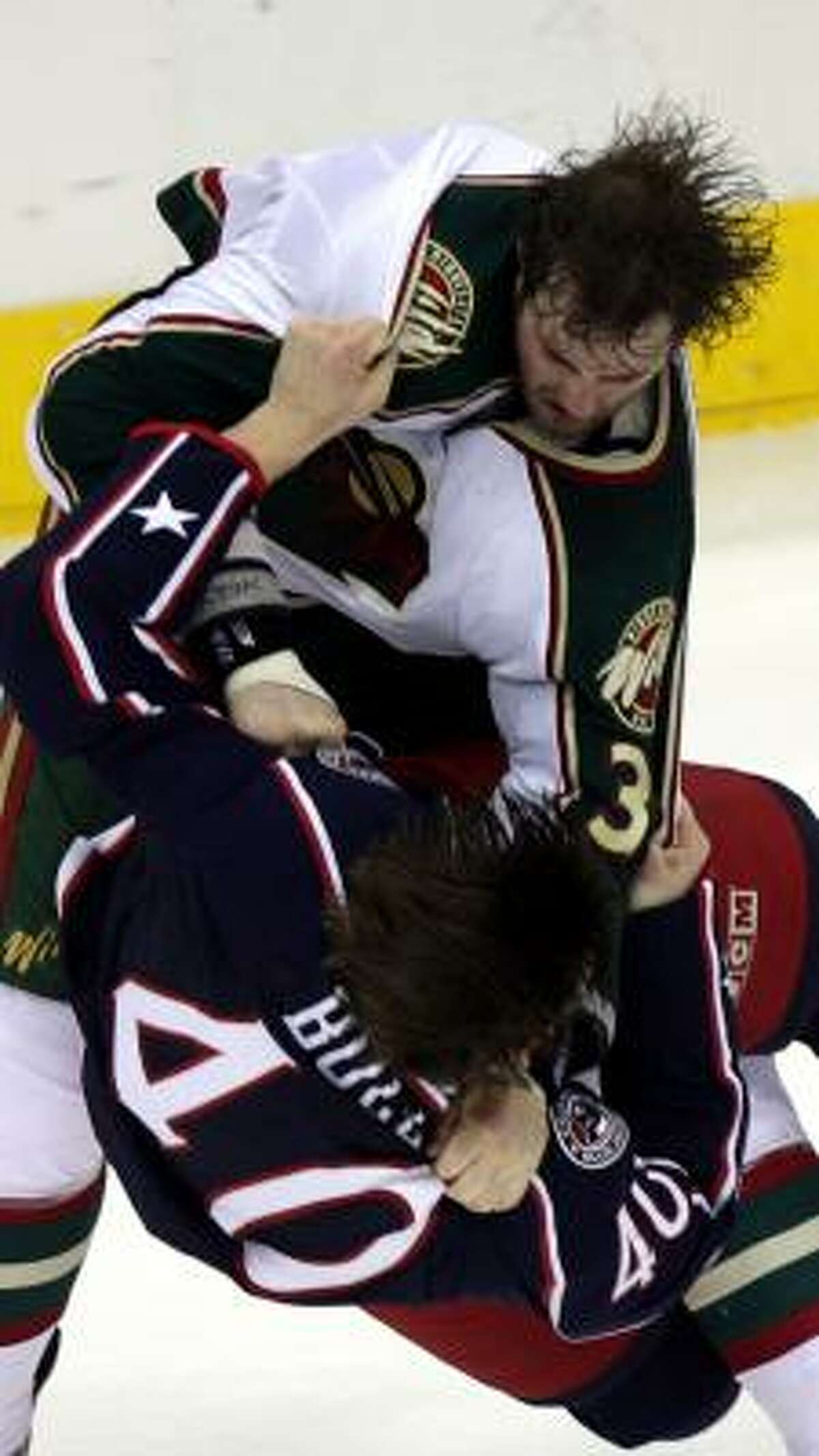 Minnesota's Derek Boogaard (a former Houston Aero) slams Columbus' Jared Boll to the ice.