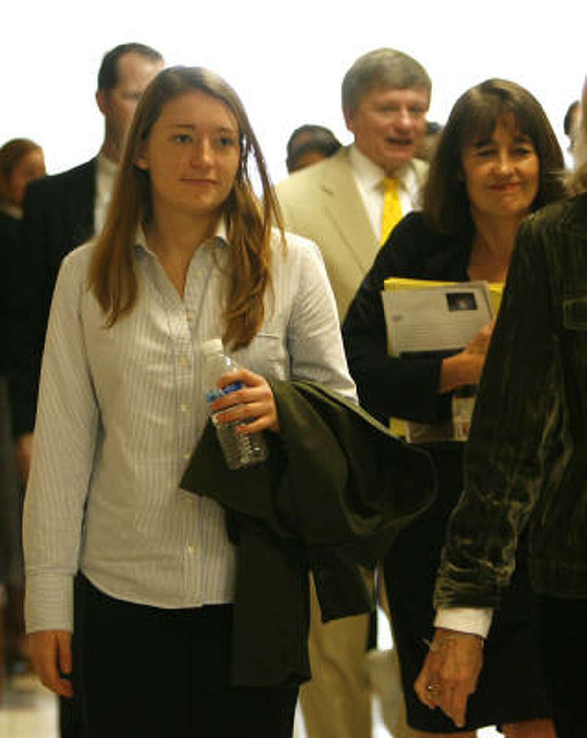 Elena Wells White, foreground, the daughter of Mayor Bill White, walks in the courthouse today with her mother, Andrea White, right.