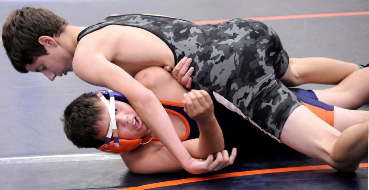 Christopher Bryant, 13, bottom, of Danbury, representing the West, wrestles and loses the 112 lb. match against Eric Manuel, of the South, during the Nutmeg Games at Danbury High on sunday.