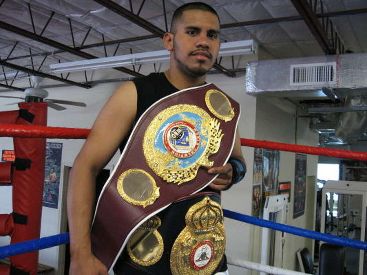 Juan Diaz displays his WBO and WBA lightweight belts at Savannah Boxing Gym.