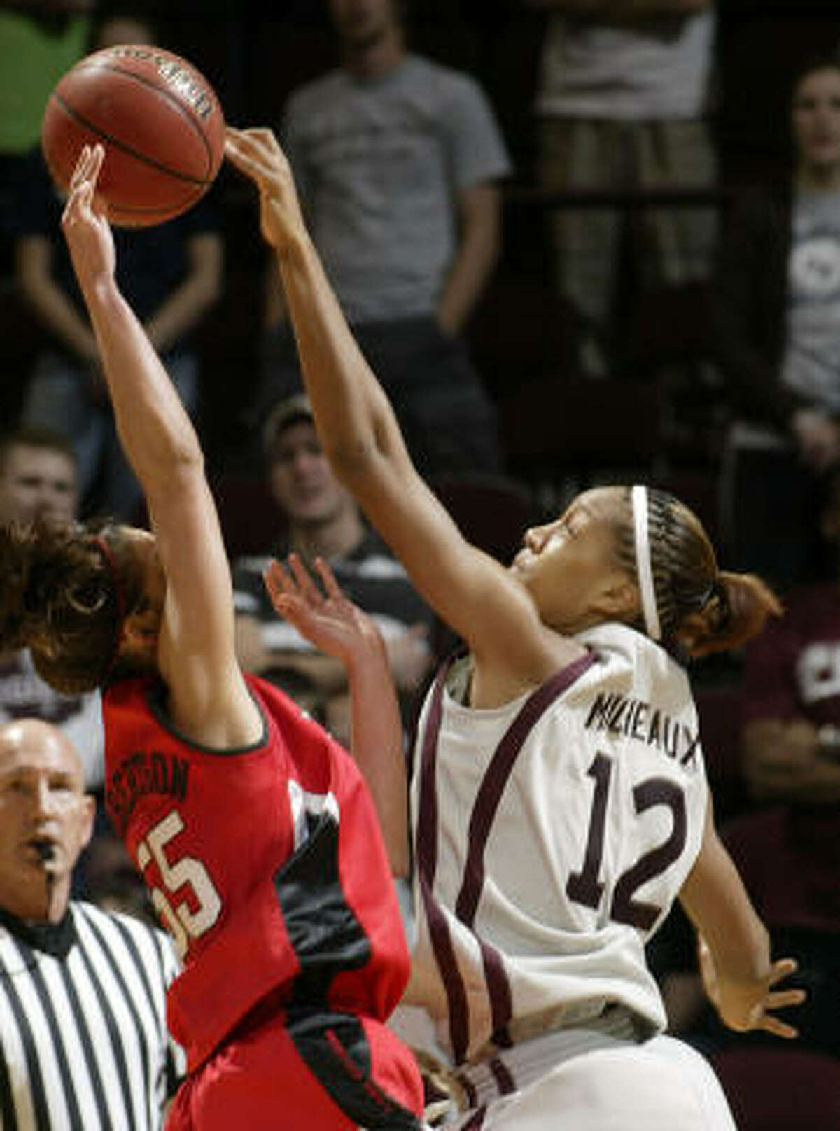 Texas Tech's Alesha Robertson, left, has her shot blocked by Texas A&M's La Toya Micheaux, one of career-high five blocks by Micheaux who also had her best rebounding game with 13.