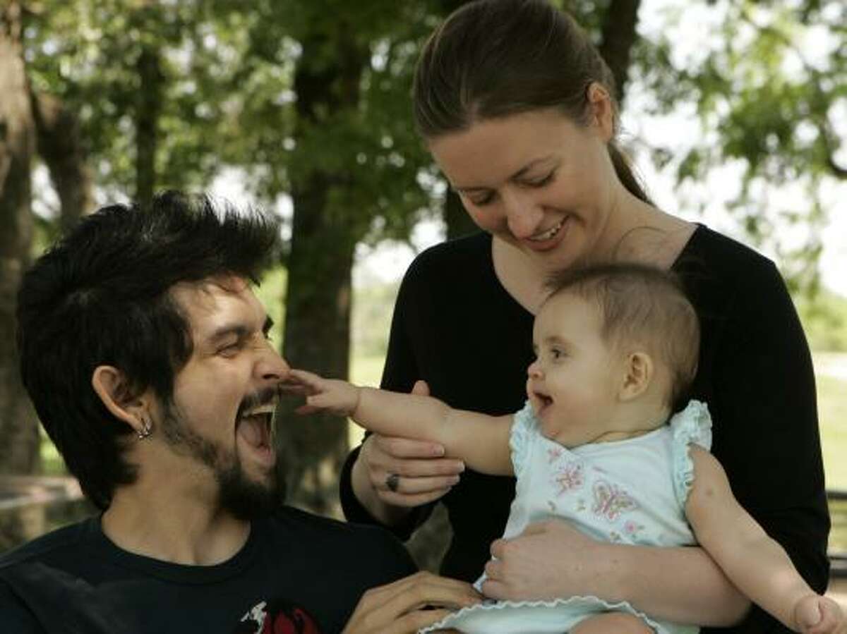 Katie Laird and husband Adam Sandoval play with their baby Ella Sandoval Laird. The couple met online and recommend researching dates on the Internet.