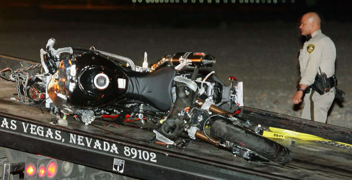 A police officer walks by boxer Diego Corrales' motorcycle after Corrales was killed in a crash in Las Vegas.
