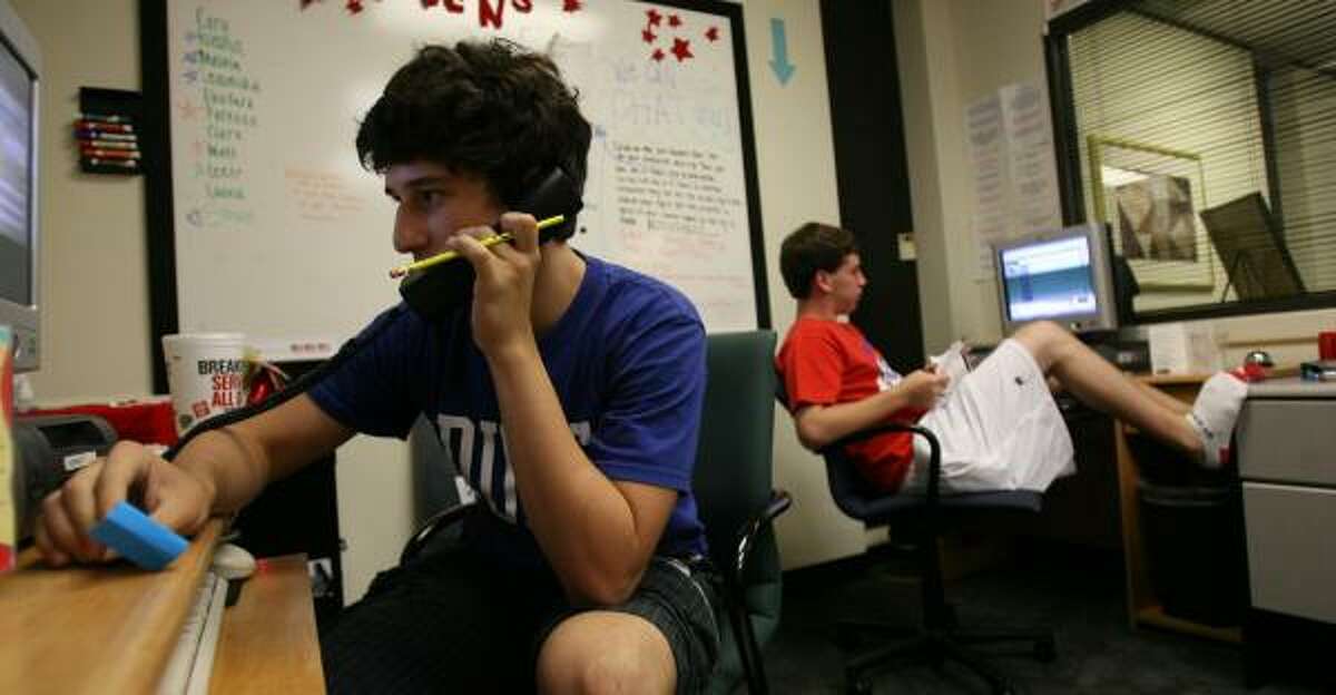 Leeor Mushin, 16, left, and Matt Smith, 16, both of Houston, work the phones at the teen crisis hot line, where teens are trained to answer calls.