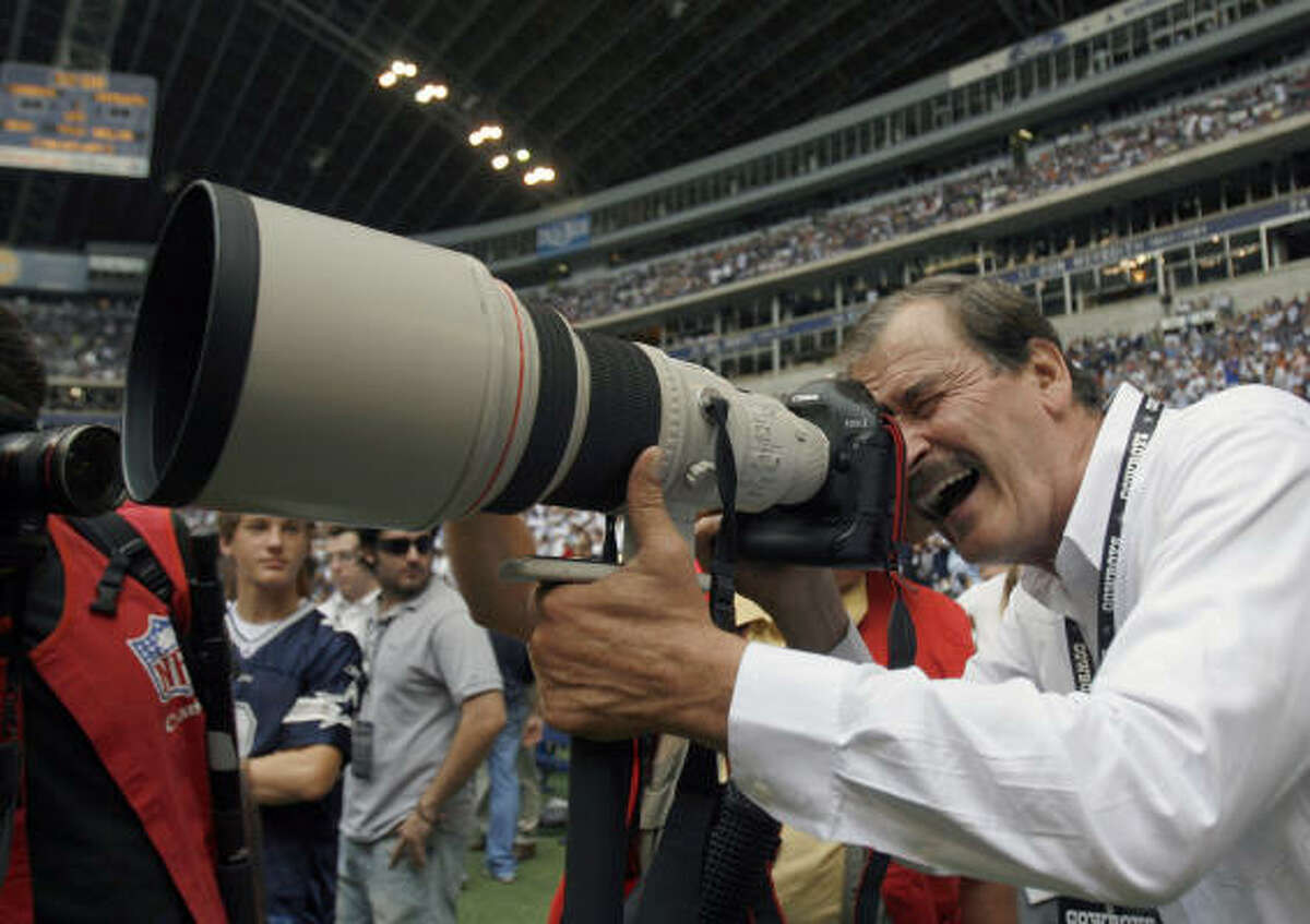 Fox looks through a camera on the sideline before an NFL football game between the New England Patriots and the Dallas Cowboys on Sunday in Irving.