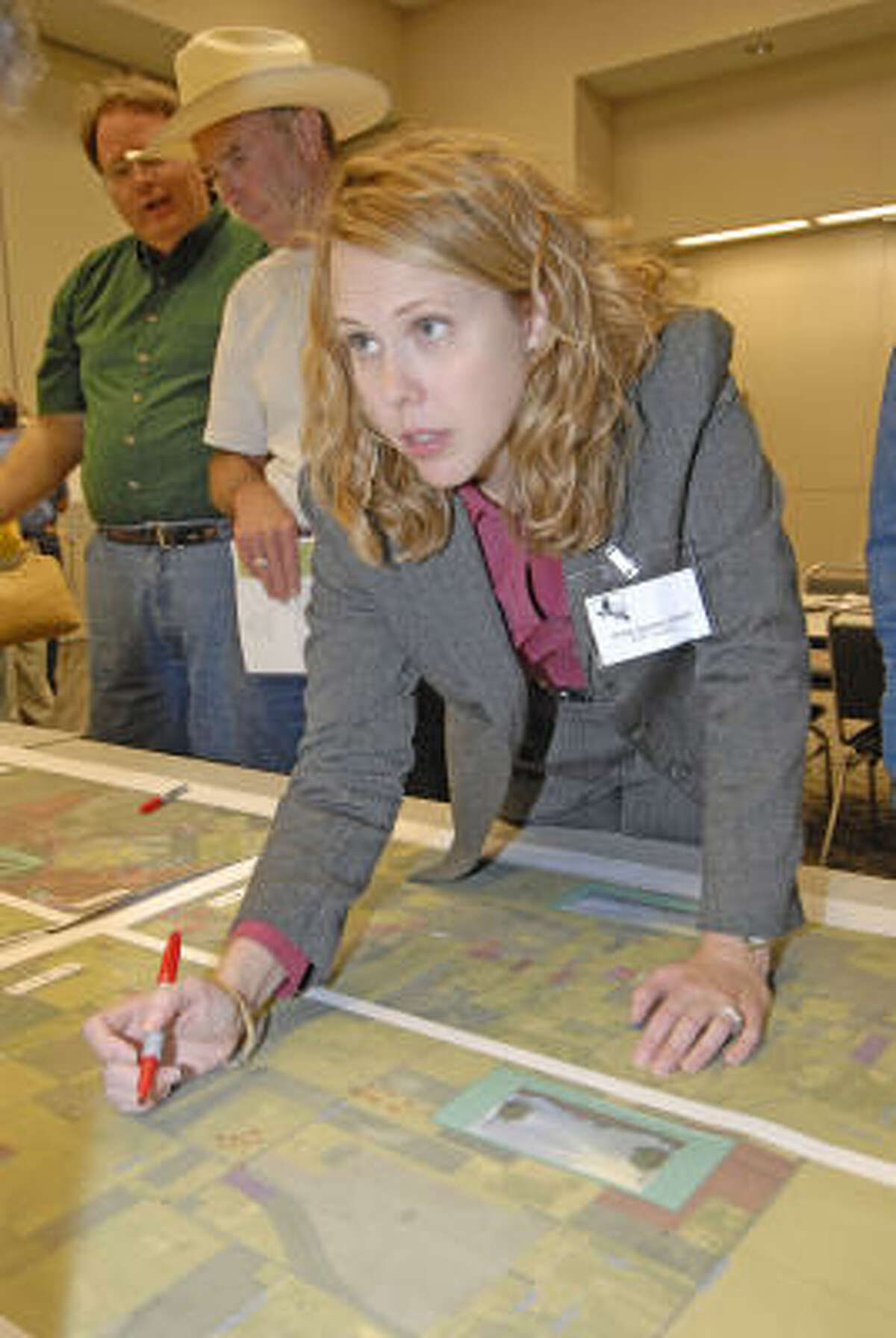 Christy Willhite, transportation planner with the Houston-Galvestion Area Council, points out an intersection on an aerial map of FM 2920 during a Nov. 14 public meeting.